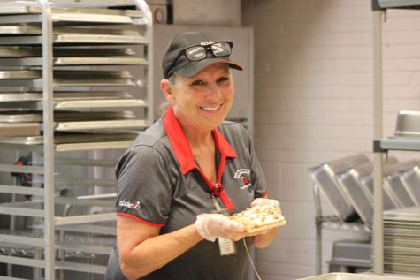 Cindy Tittle poses with a piece of pizza she is making for lunch.