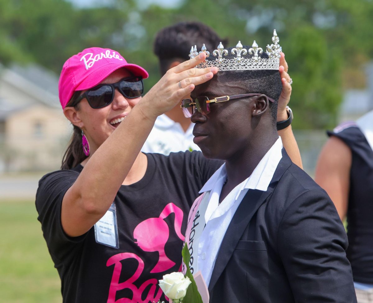 Navarre high school principal, Mrs. Windfelder. places a crown on Elijah Thompson head after being named Navarre high school prom king