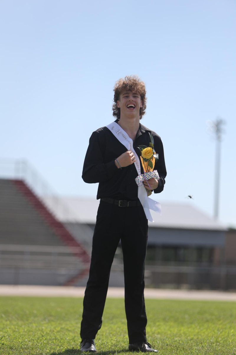 Junior NHS Homecoming Attendant Brady Hess stands in front of the NHS during the homecoming presentation.